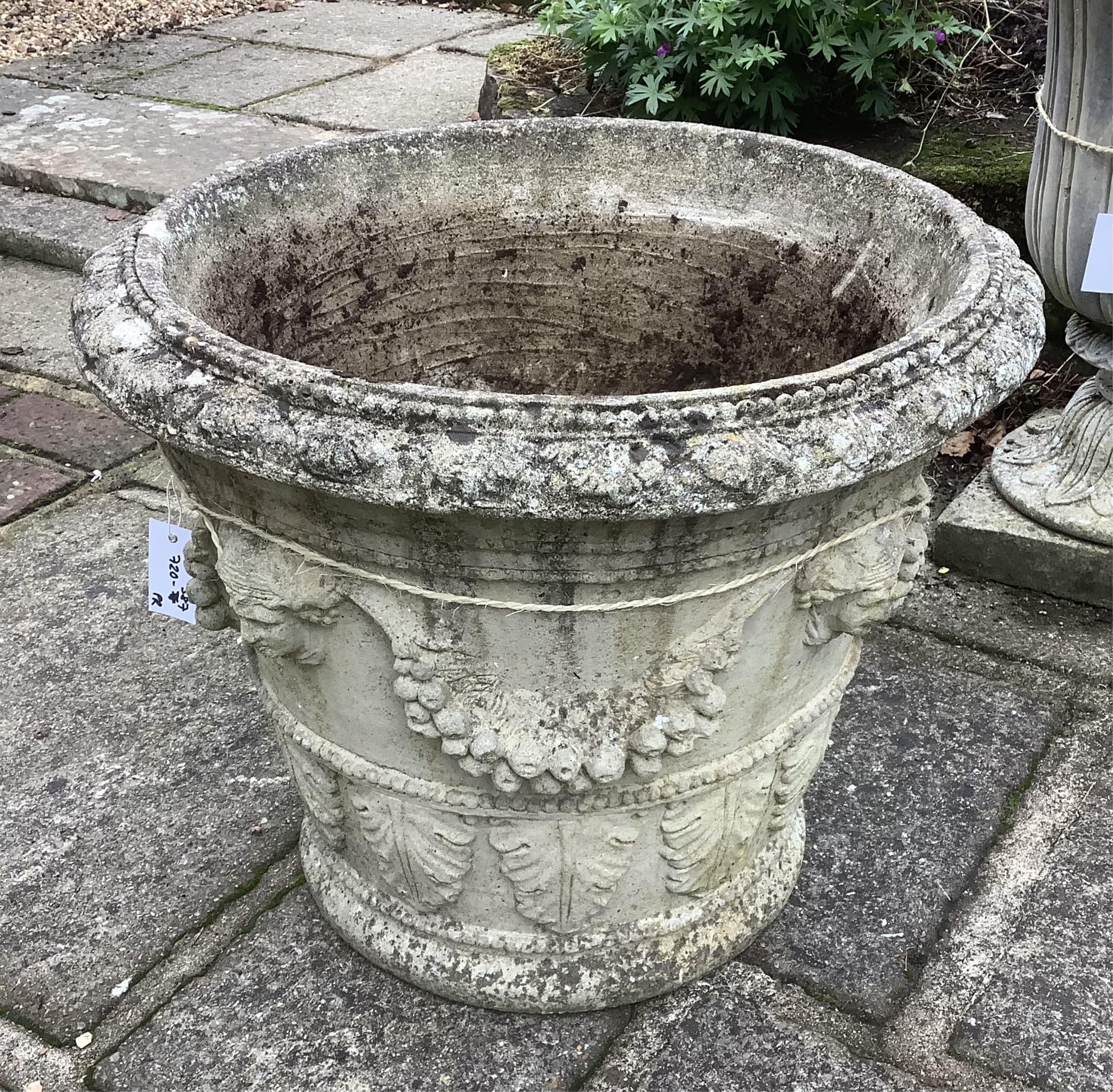 A pair of circular reconstituted stone garden urns, height 50cm, depth 60cm. planting removed. Condition - weathered otherwise good